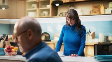 Büyük eş, evde parlak bir mutfakta kahve fincanı içip huzur içinde dinleniyor. Yaşlı kadın emekliler, olumlu emeklilik, refah ve neşeli ev anlarını aktarıyor. Kamera B.