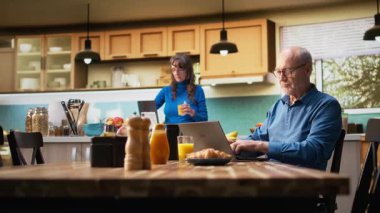 Yaşlı çift, iyi haberleri aldıktan sonra neşeli bir gülümsemeyle tezahürat yapıyor, sabah rutininde mutfak masasında oturuyorlar. Yaşlı karı koca emeklilik hayatındaki başarılarını kutluyorlar. Kamera B.