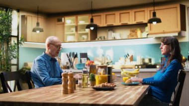 Yaşlı kıdemli bir adam, sabah kahvesi içerken kendinden geçmiş karısının, kopuk bir kadının dikkatini çekmeye çalışıyor. Bağlantı koptu, ortak. Kamera A.