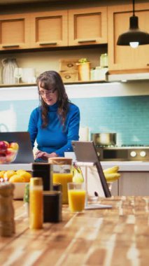 Dikey Videolu Olgun Kişi, kahve fincanıyla dizüstü bilgisayarda internette geziniyor ve emeklilikte rahat yaşam tarzını vurguluyor. Huzurlu bir hayat ve ev hayatı. Kamera A.