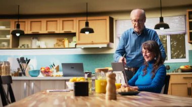 Yaşlı bir çift, evde sakin bir sabah geçiriyorlar. Bir tabletle kahve içip sohbet ediyorlar. İnterneti eğlence için kullanırken kadın ve erkek sohbet edip gülüyorlar. Kamera A.