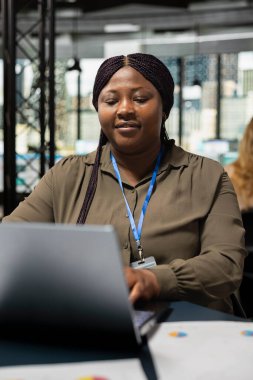 Siyahi şirket ortağı, bir strateji belirlemek için hazırlanan belgeleri gözden geçirir, bilgisayarındaki anahtar verileri güvence altına alır. Projenin geliştirilmesi ve tamamlanması için kaynak tahsis eden iş kadını.