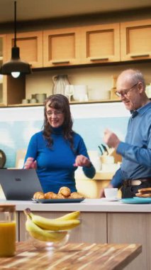 Dikey Video Oynatıcı yaşlı insanlar mutfakta dans ediyor ve sabah müziğinin tadını çıkarıyor. Romantik tutku, mutluluk ve evde sevgi dolu bir ilişkinin güzelliğini gösteren havalı ve şapşal hareketler. Kamera.