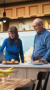 Dikey Video sunucusu evli çift dans hareketleri yapıyor ve mutfakta gülüyorlar, sabahları müzik dinliyorlar ve birlikte şapşallaşıyorlar. Enerjik ruh hali pozitif enerji yayar.