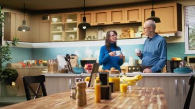 Apartman mutfağındaki yaşlı insanların portresi emekli hayatı yansıtan kahve fincanıyla sakin bir anın tadını çıkarıyor. Rahatlık ve neşeli bir ev hayatı gösteren yaşlı bir çift. Kamera A.