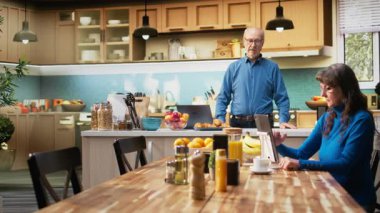 Son sınıf öğrencisinin portresi mutfağında kahve ve hamur işleriyle dinleniyor. Rahatlamış bir yaşam tarzı, neşeli bir yaşam tarzı ve evde emekli olmanın sakin bir havası. Kamera A.