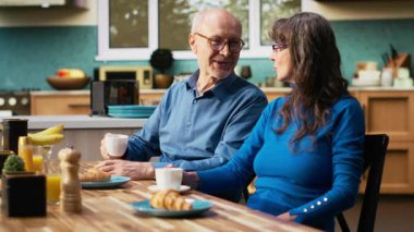 Yaşlı karı koca kahve fincanlarıyla tatlı anlar yaşar, birbirlerine bakar ve sabahları sohbet ederler. Huzurlu bir emeklilik, pozitif bir yaşam tarzı ve ev hayatının keyfi. Kamera B.