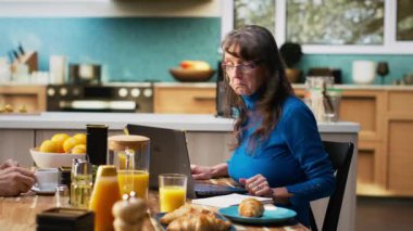 Üst düzey evli çift ders kitabına birlikte alışveriş listesi yazıyor. Temel ihtiyaçlar için alışveriş listesi hazırlayan erkek ve kadın. Emeklilik sırasında sağlıklı beslenme. Kamera B.