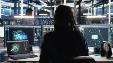 VFX HUD 'lar ile AI LLLM' yi görselleştirmek için holografik simülasyon kullanan veri merkezindeki programcı. Bilgi işlem uzmanı sunucu merkezinde dijital ikiz görüntüleme kullanarak yapay zeka altyapısını denetliyor.