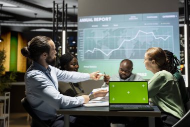 Tecrit edilmiş bir bilgisayar ile geç bir danışma kurulu toplantısına katılan çeşitli meslektaşlar, bir strateji geliştirerek ve proje gündemi için hedefler belirleyerek. Uzmanlar şirket içindeki güncellemeleri gözden geçiriyorlar.