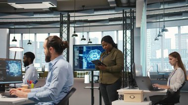 Kadın programcı, yazılım sorunlarını düzeltmek ve sistem istikrarını iyileştirmek için yapay zeka algoritmalarını tablet üzerinde kodluyor. Teknoloji başlangıç ofisindeki kadın ayarları ayarlamak için aygıt, kamera A 'yı kullanıyor.