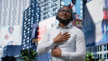 En sevdiği müzikle şarkı söyleyip dans eden modaya uygun Afrika kökenli Amerikalı bir adam sokakta kulaklıkla harika dans hareketleri yapıyor. Kendine güvenen sokak tarzı ve şehir hayatının akışı. Kamera B.