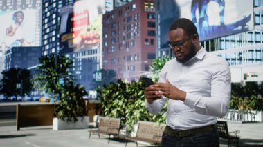 Siyah adam kötü haberden hayal kırıklığına uğradı. Şehir caddesinde yürürken, canı sıkkın ve endişeli hissediyor. Canlı mimari ve şehirciliği ön plana çıkaran metropoliten gökyüzü. Kamera A.