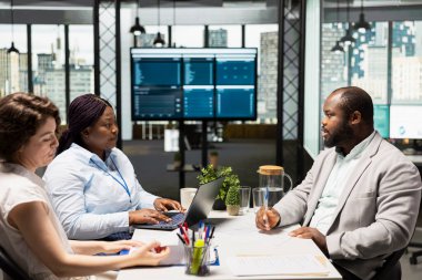 Seçim sürecinden sonra yeni organizasyon pozisyonunu doldurmak için İK yöneticisi ve asistanı ile iş sözleşmesi imzalayan Afrikalı Amerikalı aday. Birini işe almak..