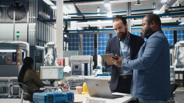 Bir üretim denetimi sırasında güneş paneli sistemlerini analiz eden bir grup endüstri uzmanı mühendislik doğruluğu, kalite kontrolü ve fabrika işletim verimliliğini sağlıyorlar. Dayanıklılık. Kamera A.