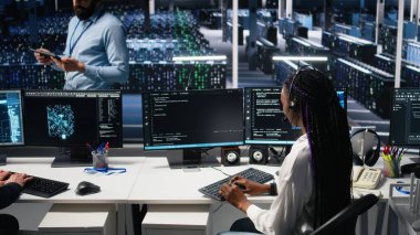 Veri Merkezi bilgisayar bilimcisi kullanıcı teknik desteği sağlamak için yapay zeka asistanı kullanıyor. Sunucu çiftliğindeki Afrikalı Amerikalı kadın yapay zeka ve kamera A 'nın yardımıyla canlı destek aramalarını yönetiyor.