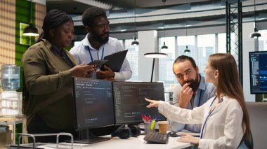 Takım çalışması programcıları yazılım uygulamaları geliştiriyor, kodu optimize etmek için birlikte çalışıyorlar. Teknik ekip ofiste beyin fırtınası yapıyor, yapay zekayı kullanarak darboğazları ve kamera A 'yı çözüyor.