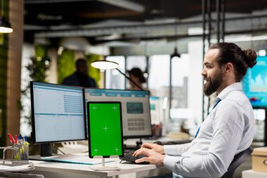 Ofiste yeşil ekran ile iş planlaması yapan çalışanlar, hedeflerle aynı hizayı sağlamak ve performans ölçümlerini optimize etmek için yazma raporları hazırlarlar. Şirket tahminleri.