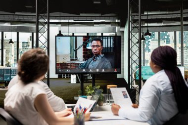 İş geçmişi, kariyer hedefleri ve kurumsal iş gücü seçimine hazırlık niteliklerini yeniden değerlendirmek için bir adayla çevrimiçi video görüşmesi yapan alıcılar. İşe alma süreci.