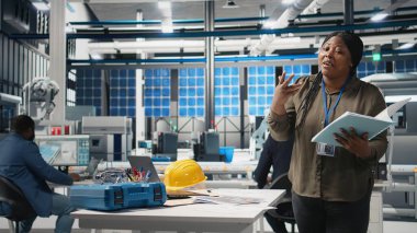 Profesyonel kadın sunucu, yüksek teknolojili bir güneş paneli fabrikasında sürdürülebilir çevre dostu çözümler için yenilik sergileyen yeşil enerji iş yatırımını tartışıyor. Pazarlama reklamı. Kamera A.