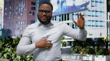 Siyah adam şehir merkezindeki kaldırımda modern yaşam tarzı ve kültürel çeşitlilik için tasasız dans ediyor. Mimari ve dinamik, eğlenceli, eğlenceli bir şehir atmosferi var. Kamera B.