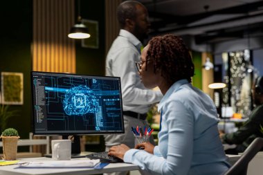 Afrika kökenli Amerikalı kadın, birlikte çalışma alanında veri paylaşımı ve optimizasyon modelleri sinerjisi kullanarak, verimlilik tanınması için yapay zeka entegrasyonunun başarısından memnun. İlerleme refahı.