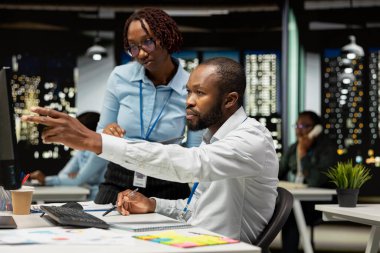 Siyah kendine güvenen iş ortakları geceleri masaüstü bilgisayarındaki ölçümleri analiz ederek rapor yazma ve sonuç ve başarı sürme üzerine odaklanıyorlar. Birlikte fazla mesai yapıyoruz..