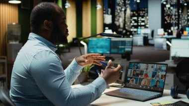 Uzaktan kumandalı bir web sitesine katılan Afrikalı Amerikalı işçiler bilgisayardaki webcam kullanarak, paydaşlarla mesai saatleri dışında iletişim kuruyor. Ağ oluşturma oturumu için fikir alışverişinde bulunan yönetici yardımcısı.