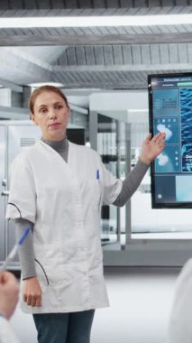 Laboratuvardaki dikey video biyoteknoloji uzmanı meslektaşlarına yenilikçi DNA dizileme projesi sunuyor. Stratejik brifing sırasında araştırmacılara 3 boyutlu biyolojik modeli gösteren laboratuar yöneticisi