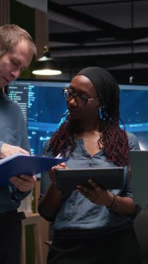 Yüksek makamlarda yapay zeka algoritmaları geliştiren mühendislik ekibinin dikey video portresi. Ekip çalışanı meslektaşlar ekranda gösterilen 3D sinir ağı beyin modelleri, kamera A