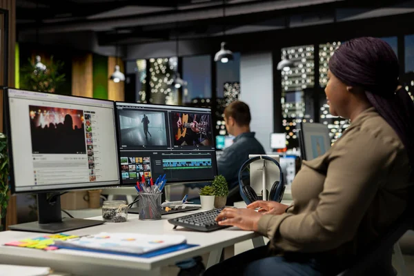 Ajans ofisinde video yapım sektöründe çalışan kadın uzman editör, renk derecelendirme yapıyor ve çift monitörlerde bir montaj yaratıyor. Multimedya teknoloji araçları ile yaratıcı süreç.