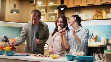 Ebeveynler ve kızları yemek pişirirken karaoke yapıyor ve dans ediyorlar. Hafta sonu etkinliği olarak ev yapımı pizza yapıyorlar. Evdeki çatal bıçaklarla şarkı söyleyen eğlenceli insanlar. Kamera B.