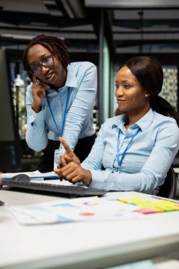 Proje stratejisi ve brifingde işbirliği yapan siyahi işçiler, performans ölçümlerini çalıştırmak için çizelgelerden elde edilen verileri kullanıyorlar. Ekip çalışması ve iş ortaklığı.