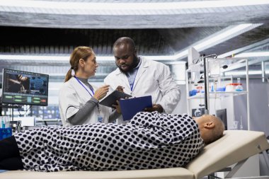 Yeni bir ilaç deneyi sırasında hasta tepkilerini gözlemleyen laboratuvar araştırmacıları, ilaç ve biyoteknolojide ilerleme kaydetmek için dozaj tepkisini ve tedavi sürecini belgeliyorlar. Yenilik.