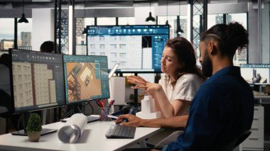 Mimari tasarım yazılımı ile çalışan mühendis ve emlak geliştiricisi, emlak genişlemesi ve kentsel kalkınma için proje planlarını ve yenileme stratejilerini analiz ediyor.