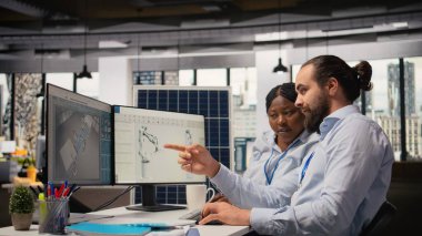 Araştırma ve geliştirme ofisindeki iş arkadaşları, sürdürülebilir güneş paneli montajı için üretim hatlarını yükseltmek için CAD programını kullanıyorlar. Mühendislerden oluşan bir ekip, güneş pillerinin çevre dostu olması için simülasyon yapıyor. Kamera A.