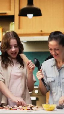 Dikey Veliler ve Kızları mutfakta şarkı söyleyip dans ederken, ev yapımı pizza pişirirken ve hafta sonu etkinliği için aptalca davranırken eğleniyorlar. Evde neşeli bir aile. Kamera B.