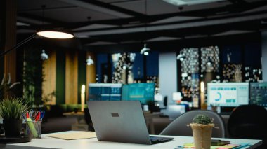 Geceleri boş bir iş bürosunda veri raporları ve analizler, gece yarısı parıltısı ve şirket yönetim kurulunda ışıklar sergileniyor. Yönetim için finansal tahminleri olan modern çalışma alanı.