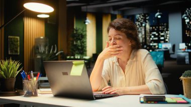 Uykusuz iş kadını ofiste esniyor uyanık kalmak için çabalıyor, geceleri aşırı yüklenmeden dolayı uykusuzluk ve iş gerginliğiyle başa çıkıyor. Rahatsızlıkla sınırları zorluyorsun. Kamera A.