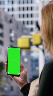 Çevrede yürüyen bir grup yayanın bulunduğu yetişkin tarafından tutulan dikey video dikey renk gösterimi, çağdaş şehir yaşam tarzını, çok kültürlü rutinini ve büyük şehir yaşamının canlı hareketini ifade ediyor