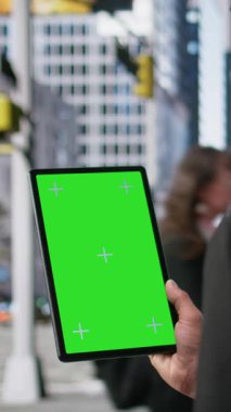 Tablette dikey video dikey yeşil ekran, iş bölgesinde yürüyen çok kültürlü yetişkinler, büyük şehir rutininin canlı hareketi ve çeşitli yayaları yakalayan gerçekçi hareketler. Kamera.