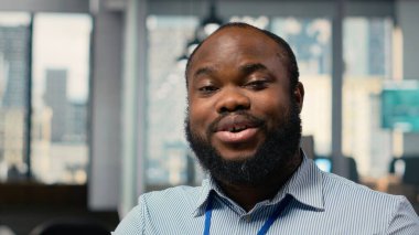 Yüksek getirili portföy operasyonlarıyla turnayı gözünden vurduktan sonra gülümseyen borsa simsarı portresi. Neşeli Afrikalı Amerikalı adam yatırım kilometre taşlarına ulaştıktan sonra sevindi.