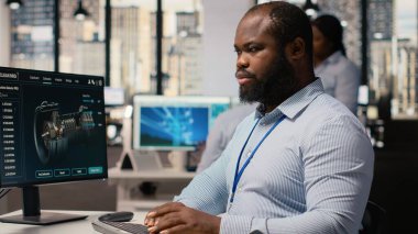 Ofisteki mühendis rüzgar türbini CAD tasarımı üzerinde çalışıyor, sürdürülebilir enerji araştırması yapıyor. Ar-Ge uzmanı yazılım kullanarak rüzgar enerjisi üreteci altyapısının dijital modellemesini yapıyor, kamera B