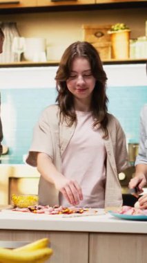 Dikey Video Ebeveynleri genç kızlara mutfakta aile pizzası tarifi yapmayı öğreterek etkin bir şekilde yemek pişirmeyi öğrenmek için gerekli adımları anlatıyor. Rahat evde ev yapımı pizza yapmak.