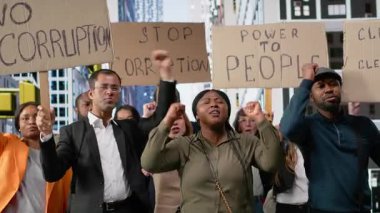Eylemcilere katılan ve yolsuzluğa karşı ayaklanan bir grup insan, karton afişler ve pankartlarla şiddet içermeyen protesto yoluyla şeffaflık ve adalet talep ediyorlar. Kamera B.