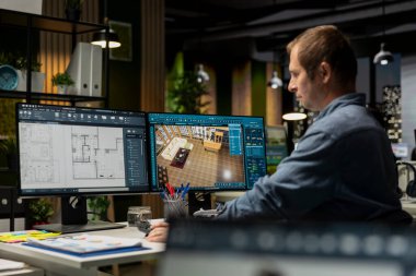 Uzman tasarımcı apartman zeminini dekore etmek için bilgisayar planları kullanıyor, elementleri yapılandırmak için mimari yazılım kullanıyor. Odaklanmış adam görüntülemeyi ve 3B modellemeyi etkinleştirmek için arayüz kullanır.