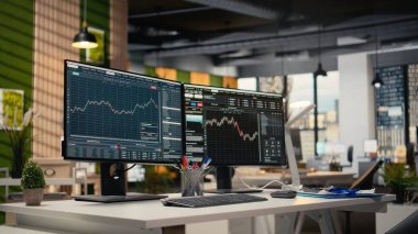 Tescilli firma ofisinde borsa grafiklerini gösteren bilgisayar ekranları. Borsa analizi ve strateji planlaması için kullanılan komisyon işi çalışma masası kurulumu