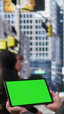 Kadın ve erkeklerin yoğun yaya geçidinde aktif hareketlerle yol almaları, çeşitli toplum yaşam biçimlerini ve modern metropol alanlarının dinamik hızlarını gösteren tablet üzerindeki dikey video modellemesi