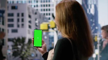 Çevrede yürüyen yayaların yanında yetişkin insanların tuttuğu dikey renkli ekran, çağdaş şehir yaşam tarzını, çok kültürlü rutinini ve büyük şehir yaşamının hareketini ifade ediyor. Kamera B.