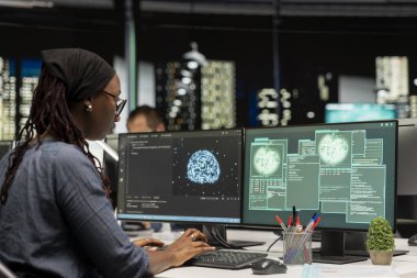 Ofisteki yazılım geliştiricisi yapay zeka kullanarak bilgisayar sistemlerinin bakımını yapıyor. Teknoloji girişimindeki Afrikalı Amerikalı kadın sunucu ağlarını etkileyen sorunları önlemek için yapay zeka kullanıyor.